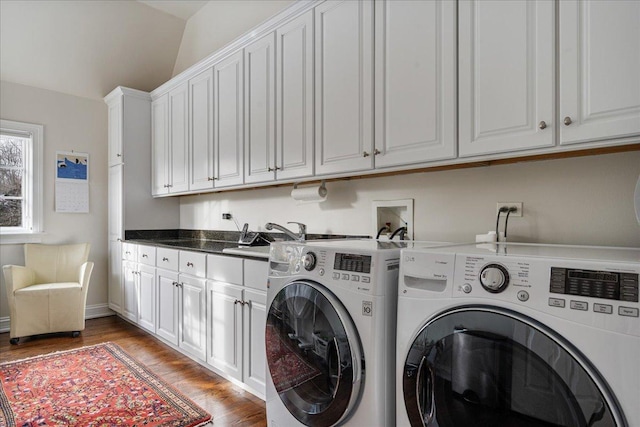 laundry area with washer and dryer, light wood-type flooring, cabinet space, and a sink