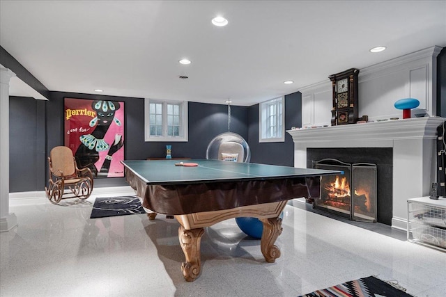 rec room featuring recessed lighting, baseboards, and a lit fireplace