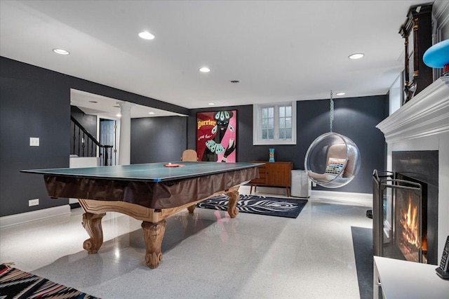 playroom featuring recessed lighting, a warm lit fireplace, speckled floor, and baseboards