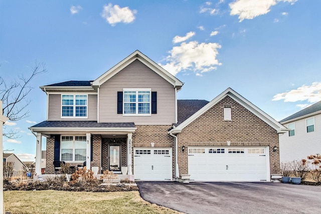 traditional-style home featuring aphalt driveway, covered porch, brick siding, and roof with shingles