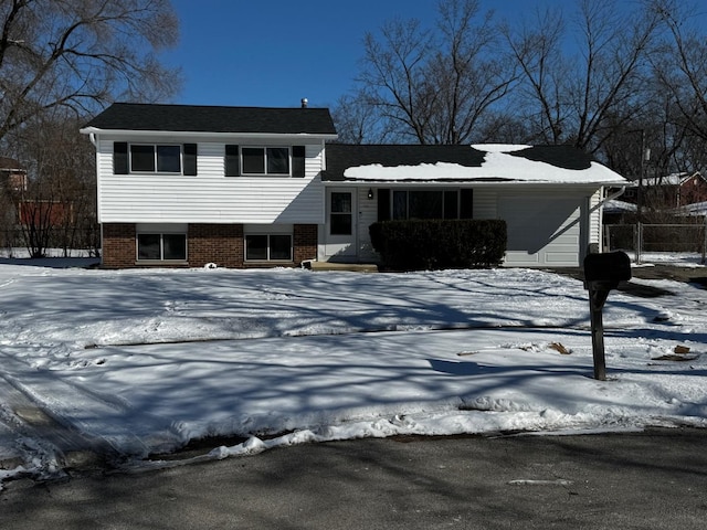 split level home with an attached garage and brick siding