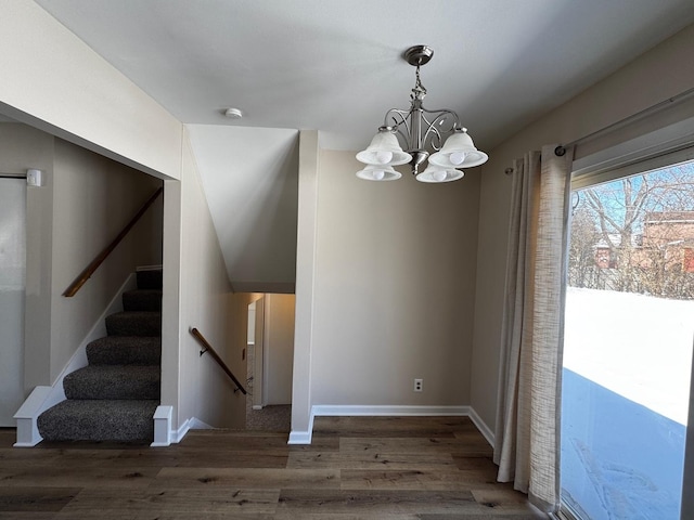 interior space with an inviting chandelier, stairs, baseboards, and dark wood-type flooring