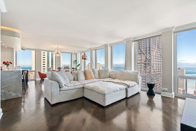 living room with baseboards, dark wood-type flooring, a wall of windows, and a notable chandelier