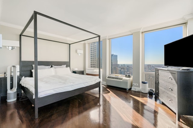 bedroom featuring baseboards, ornamental molding, wood finished floors, and a wall mounted air conditioner