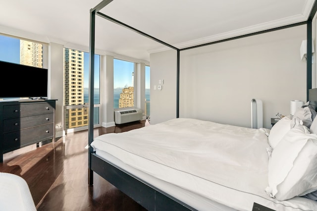 bedroom with ornamental molding and wood finished floors