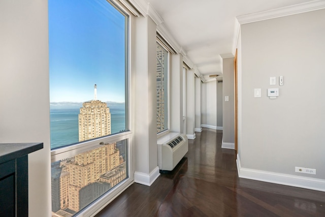 hallway featuring an AC wall unit, ornamental molding, wood finished floors, and baseboards