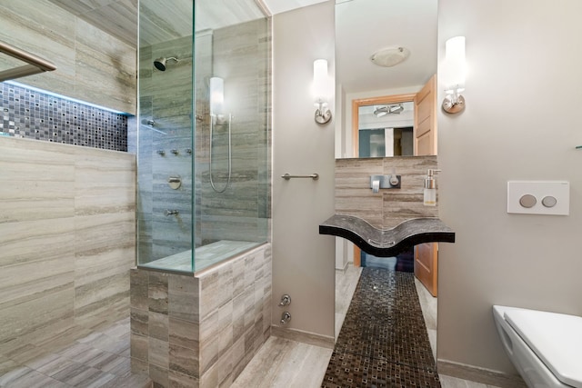 bathroom with baseboards, toilet, and walk in shower