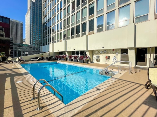 community pool with a patio area and a city view