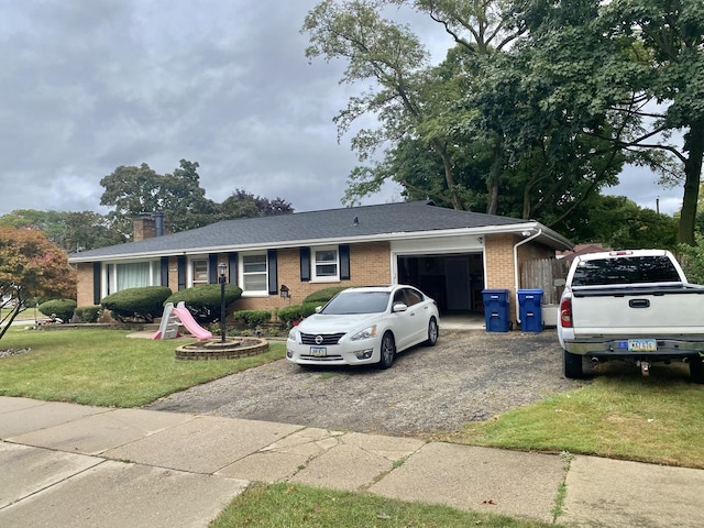 single story home with an attached garage, brick siding, driveway, a chimney, and a front yard