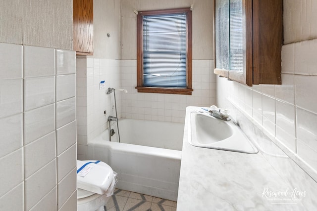 full bath with toilet, tile patterned flooring, a washtub, vanity, and tile walls