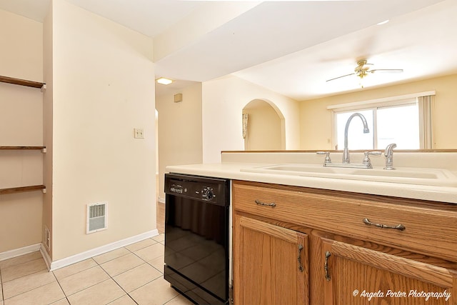 kitchen with black dishwasher, brown cabinets, light tile patterned floors, light countertops, and a sink