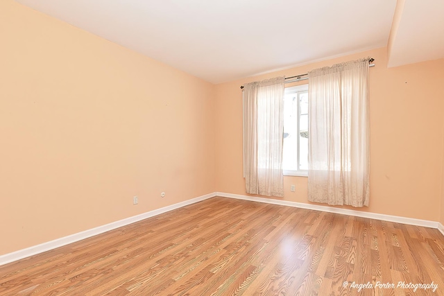 spare room featuring light wood-style flooring and baseboards