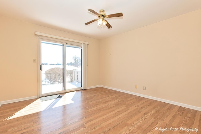 spare room with light wood-type flooring, baseboards, and a ceiling fan