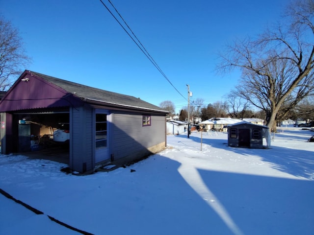 view of snowy exterior with an outdoor structure