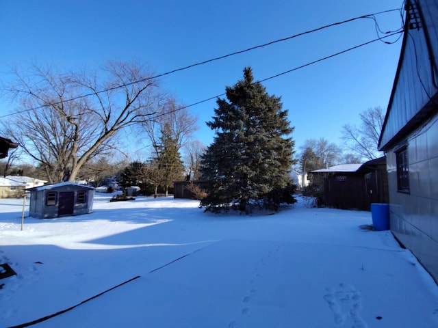 yard covered in snow with an outbuilding