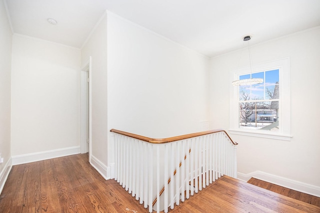stairway featuring ornamental molding, baseboards, and wood finished floors