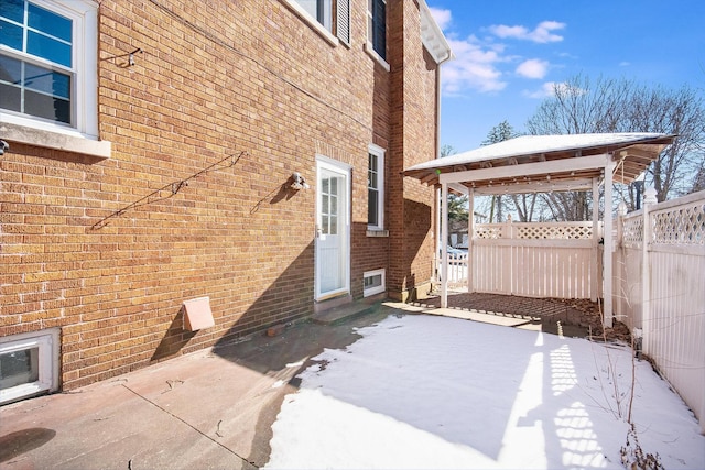 exterior space featuring fence, a patio, and brick siding