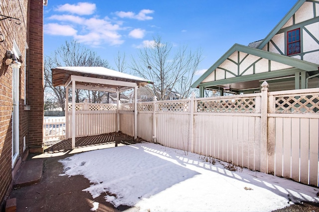 yard layered in snow featuring a fenced backyard and a gazebo
