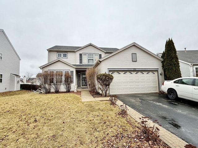 traditional-style house with a garage, aphalt driveway, and a front yard