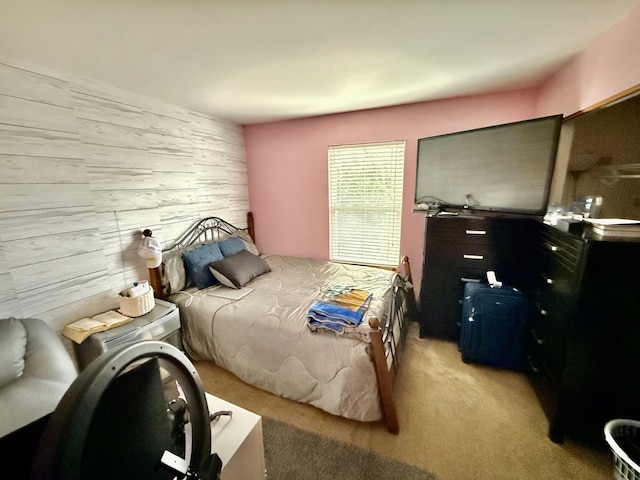 bedroom with wood walls and light colored carpet