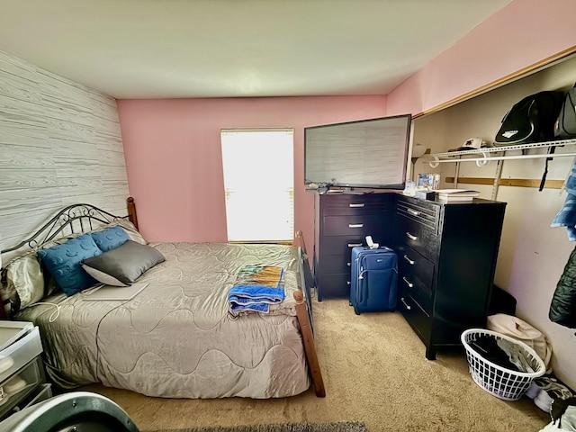 bedroom featuring light carpet and wood walls