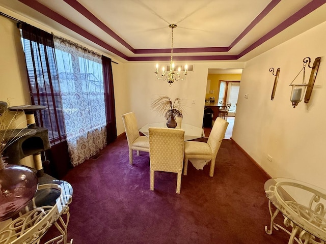 dining area featuring baseboards, visible vents, a tray ceiling, carpet flooring, and a chandelier