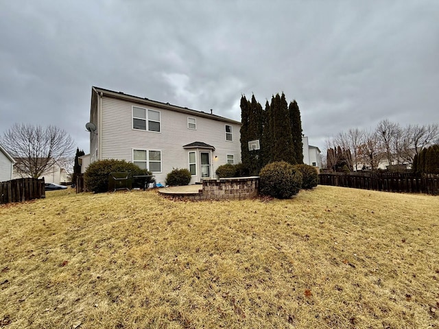 back of property featuring a yard, a patio area, and fence