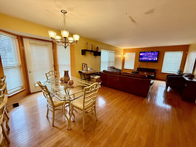 dining room featuring light wood-style flooring and a notable chandelier