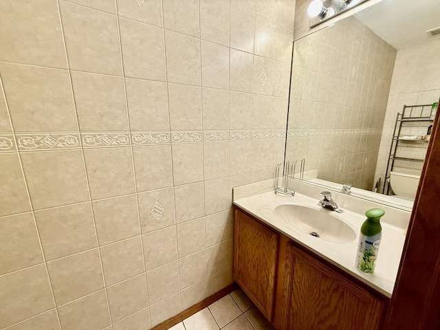 bathroom featuring vanity, visible vents, tile walls, and tile patterned floors