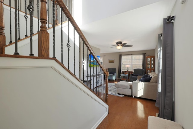 stairs featuring ceiling fan and wood finished floors