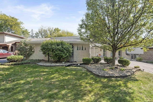 ranch-style house featuring brick siding and a front yard