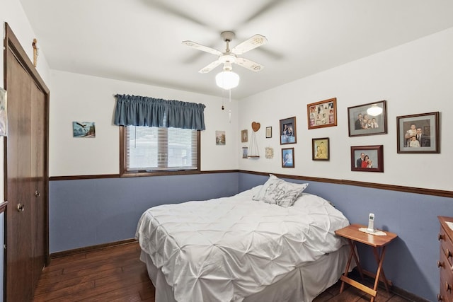 bedroom featuring dark wood-style flooring, a closet, a ceiling fan, and baseboards