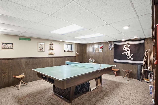 game room with a wainscoted wall, carpet, a paneled ceiling, and wooden walls