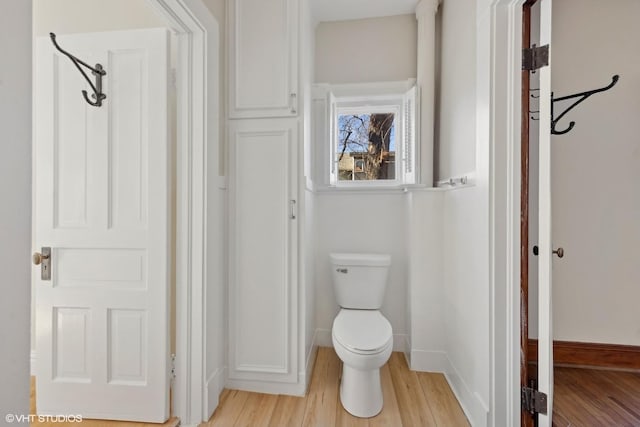 bathroom featuring wood finished floors, toilet, and baseboards