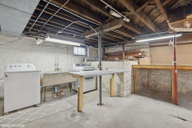 basement featuring a workshop area, a sink, and washer / dryer