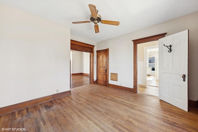 empty room with light wood-style floors, ceiling fan, and baseboards