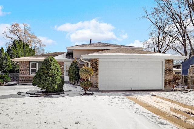 single story home featuring a garage, fence, and brick siding