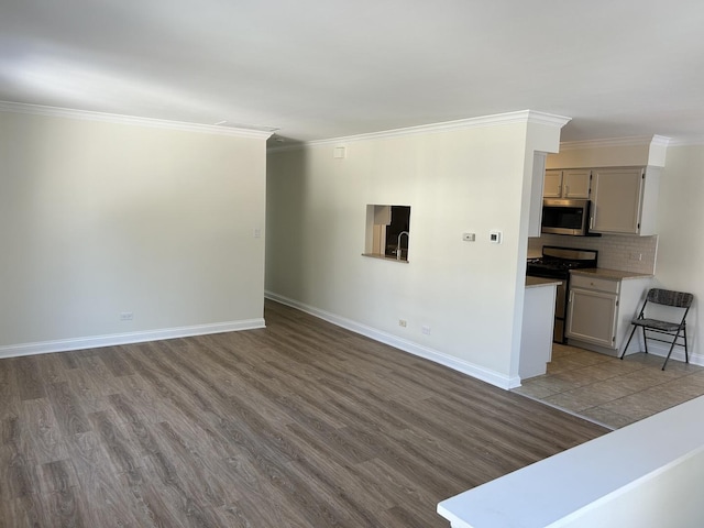 unfurnished living room with baseboards, ornamental molding, and wood finished floors