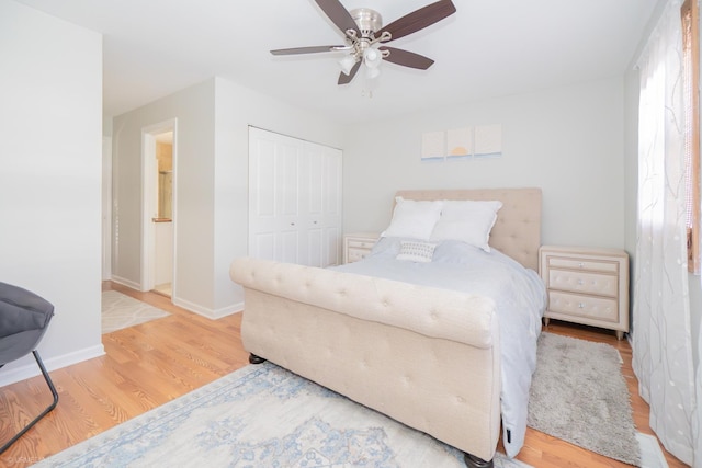 bedroom featuring ceiling fan, a closet, baseboards, and wood finished floors