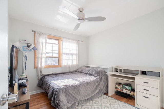 bedroom with light wood-style floors, ceiling fan, and baseboards