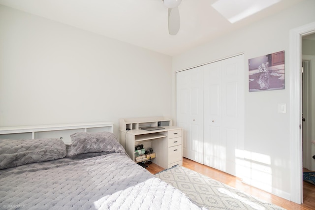 bedroom featuring light wood-style floors, a closet, and a ceiling fan