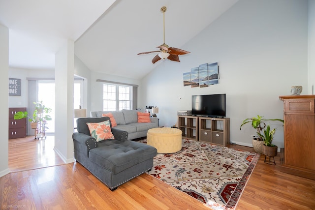 living area featuring high vaulted ceiling, a ceiling fan, baseboards, and wood finished floors