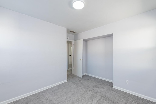 unfurnished bedroom featuring light colored carpet, visible vents, and baseboards