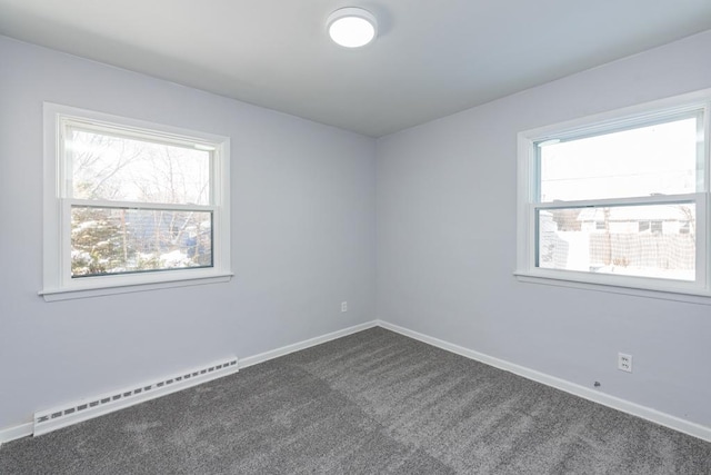 unfurnished room with a baseboard heating unit, dark carpet, and baseboards