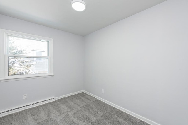 empty room featuring baseboards, light colored carpet, and baseboard heating