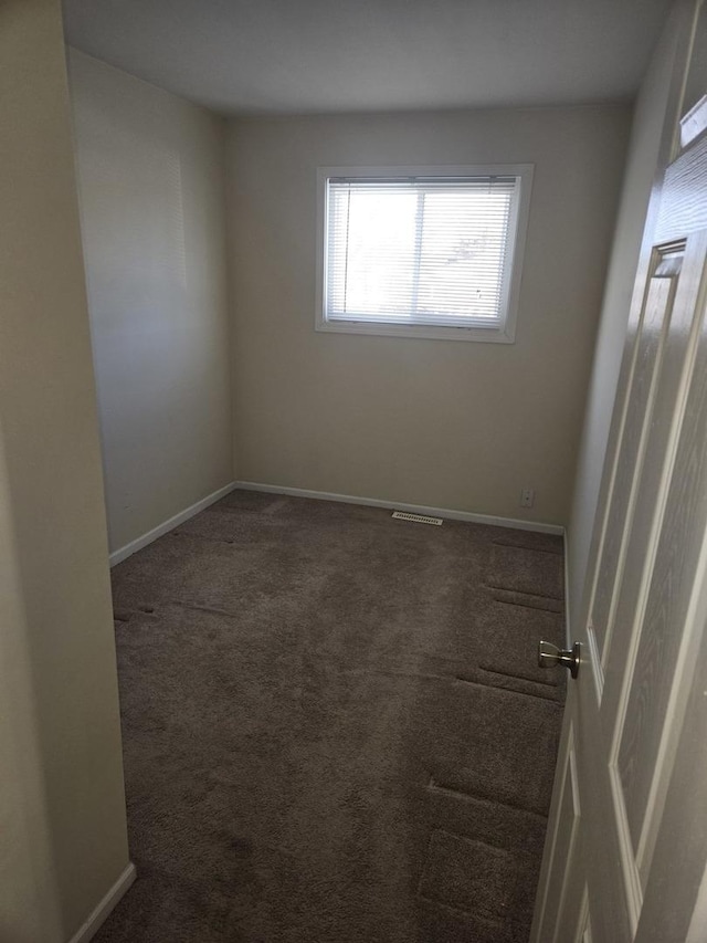 unfurnished room featuring carpet flooring, visible vents, and baseboards