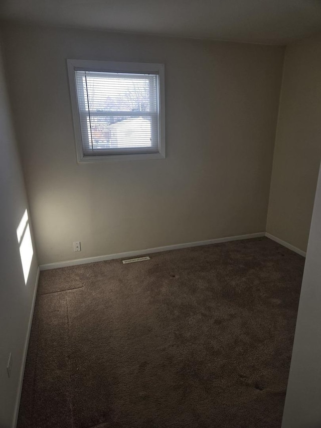 carpeted spare room featuring baseboards