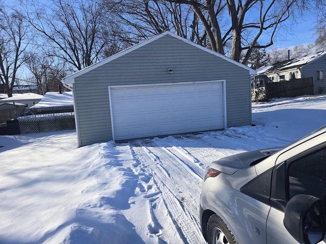 snow covered garage featuring a garage