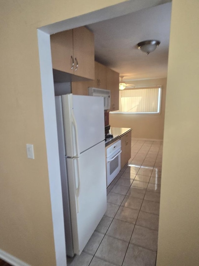 kitchen featuring white appliances, light tile patterned flooring, and a ceiling fan