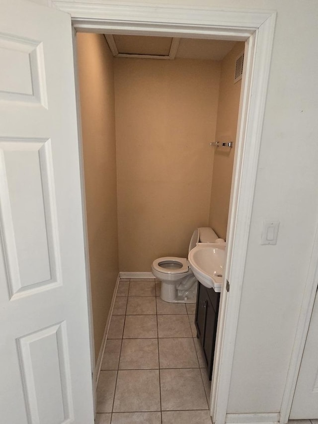 bathroom featuring visible vents, toilet, a sink, tile patterned flooring, and baseboards